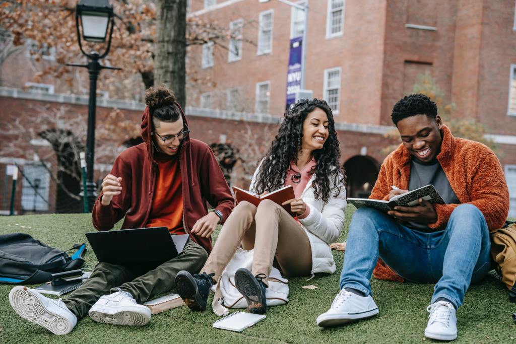 three university students sitting outside to study